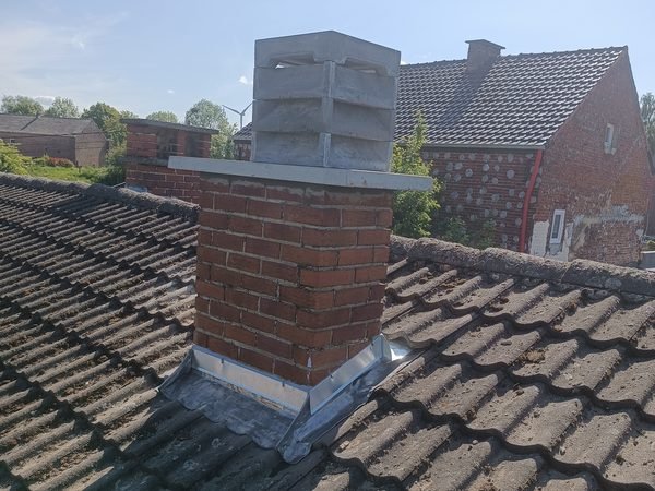 Cheminée et raccords repris sur une toiture en tuiles