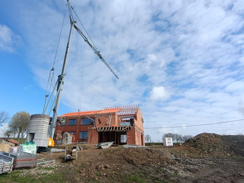 Charpente et premières rangées de tuiles sur une construction neuve, chantier Mohimont Toiture