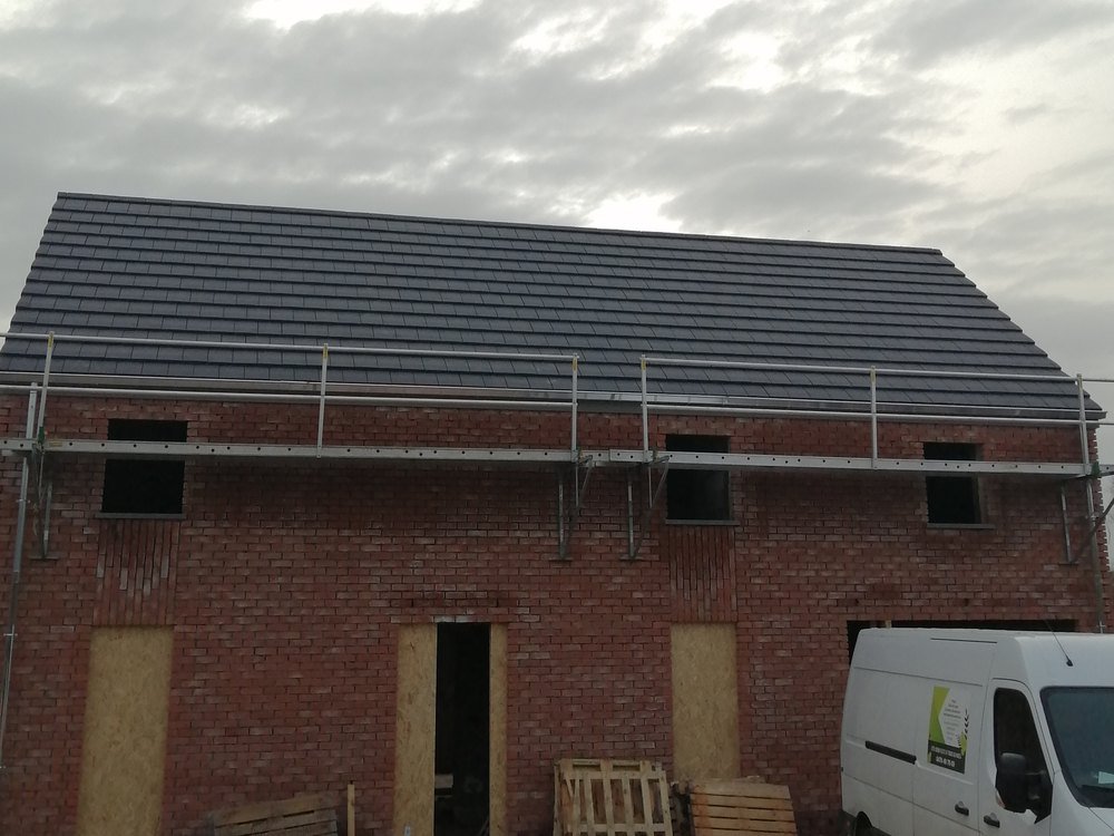 Toiture neuve en tuiles anthracite sur une maison en construction, chantier Mohimont Toiture